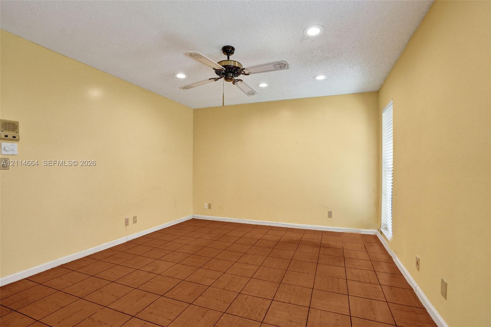 Interior room featuring tile flooring, a central ceiling fan with integrated lighting, and recessed ceiling lights