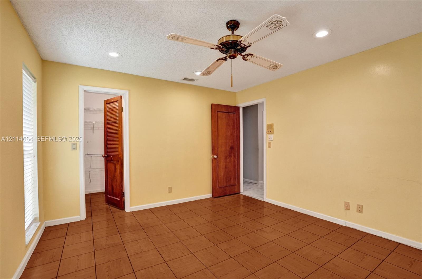 Interior space featuring ceramic tile flooring, recessed lighting, a ceiling fan, and solid wood-finish doors