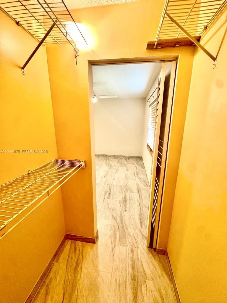 Walk-in closet featuring wire shelving and stone-patterned flooring