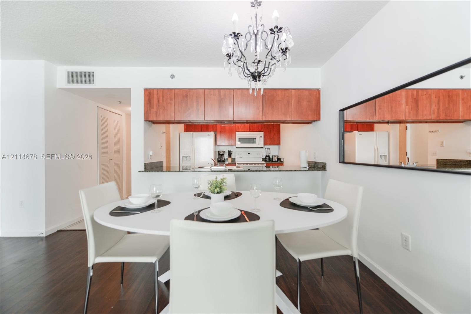 Kitchen featuring wood-finish cabinetry, a stone-surface breakfast bar, and stainless steel appliances