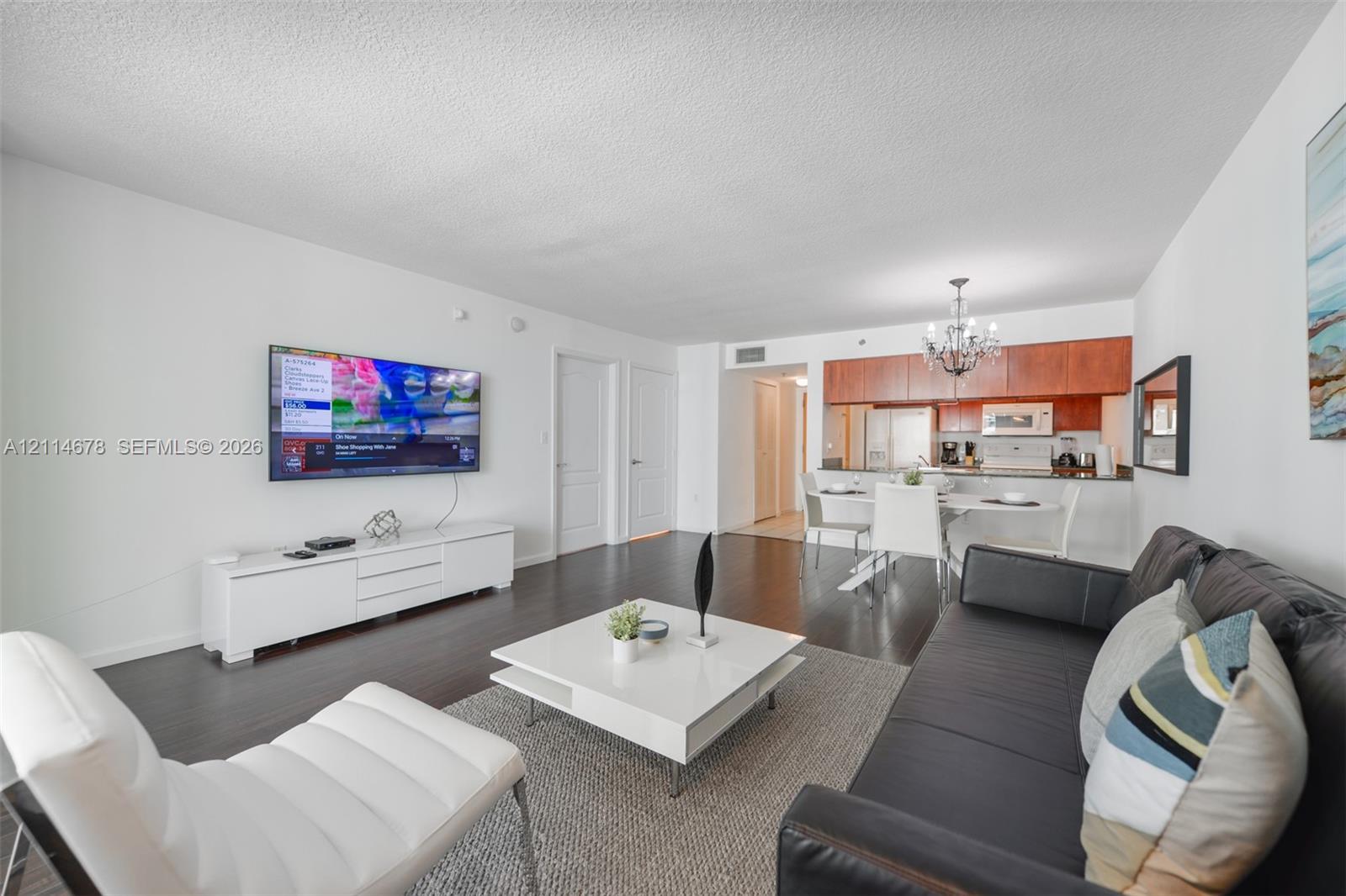 Open-concept area featuring wood-finish flooring, cherry-toned cabinetry, built-in light fixture, and recessed lighting