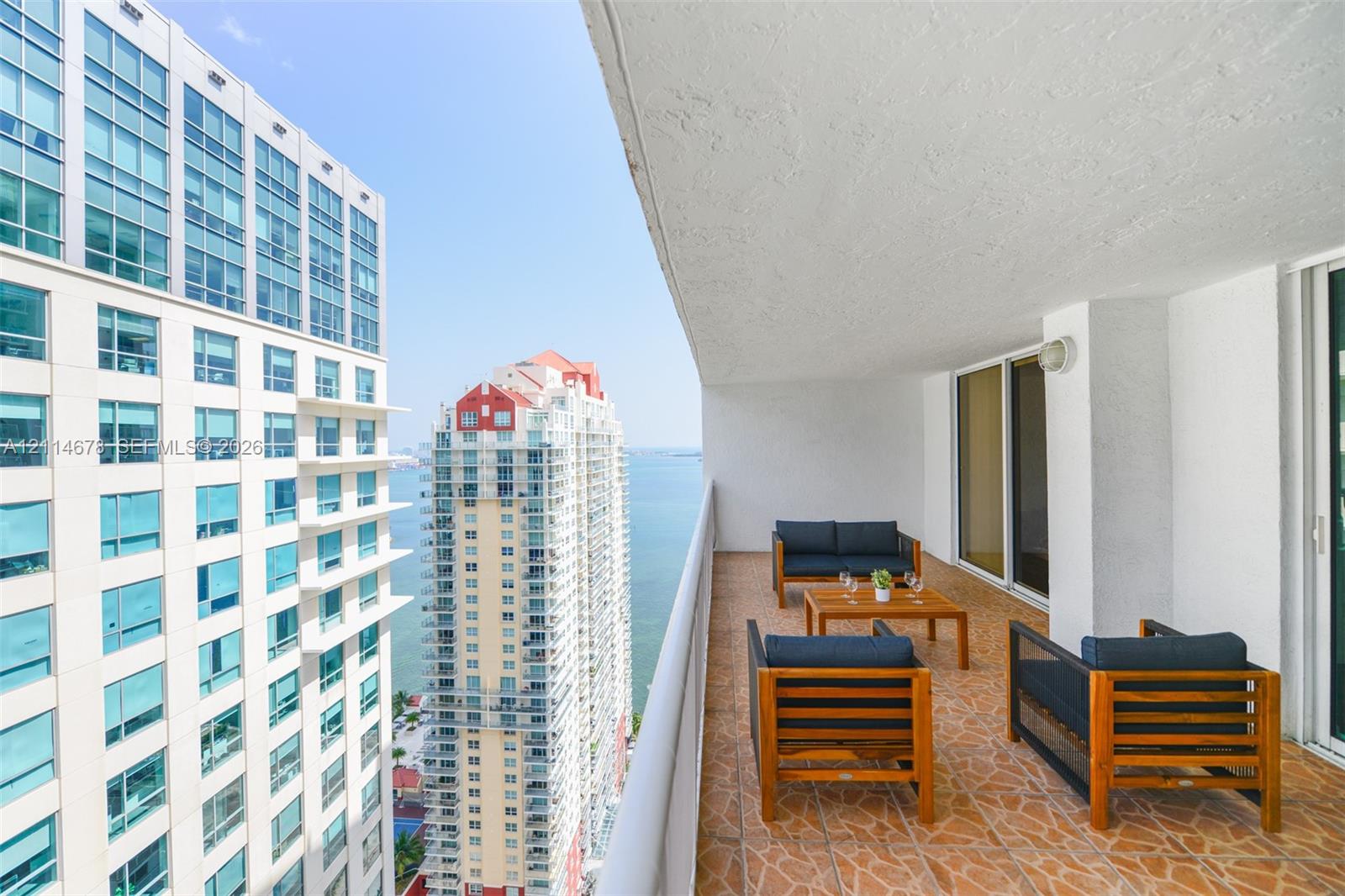 Covered balcony featuring patterned tile flooring and a wall-mounted light fixture