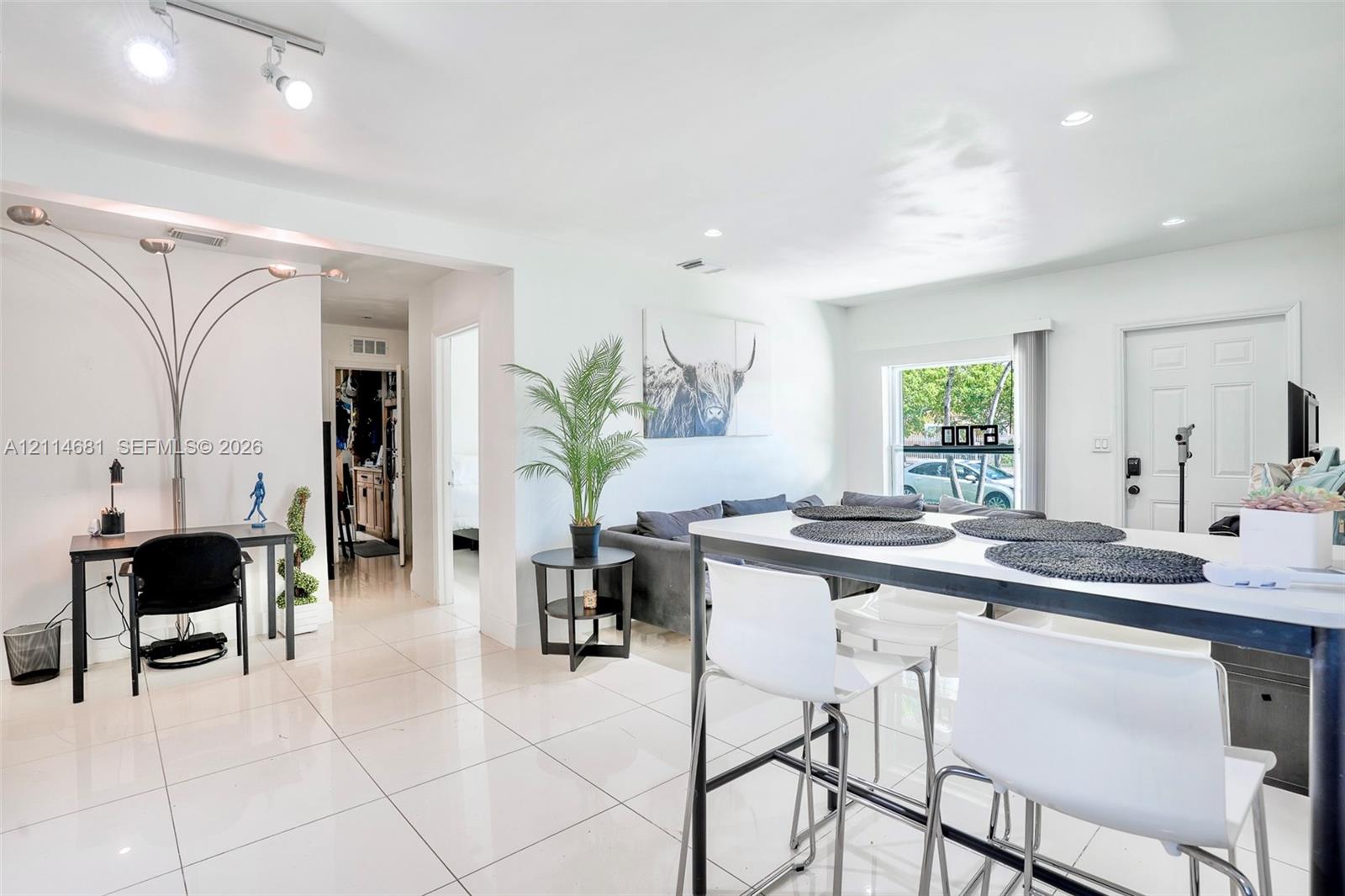Open-concept living space featuring high-gloss tile flooring and recessed ceiling lighting