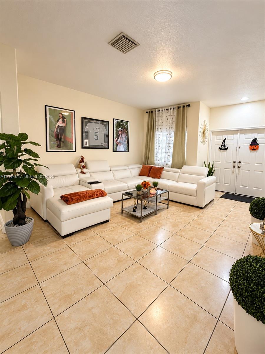 Neutral-toned tile flooring, double-entry doors, and flush-mount ceiling lighting Neutral-toned tile flooring, double-entry doors, and flush-mount ceiling lighting