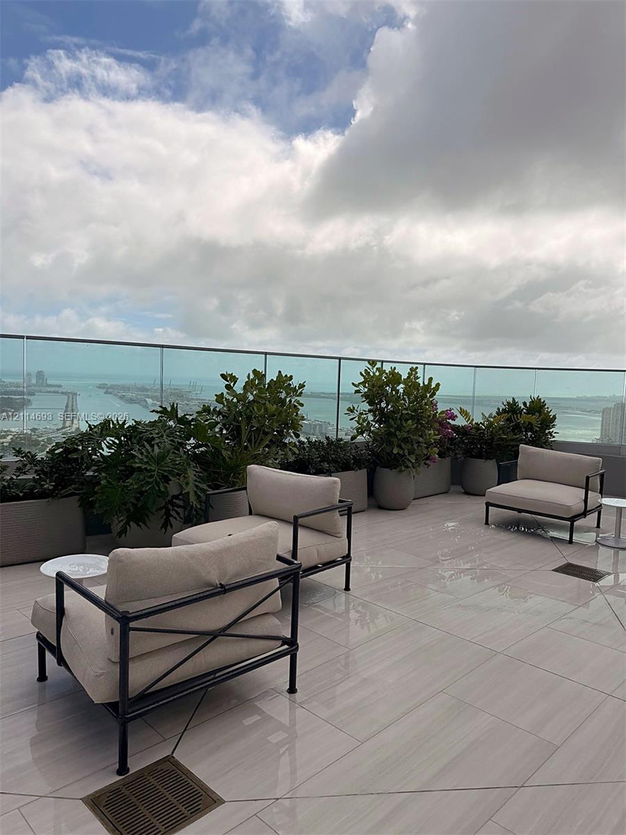 Expansive terrace featuring large-format tile flooring and a seamless glass railing