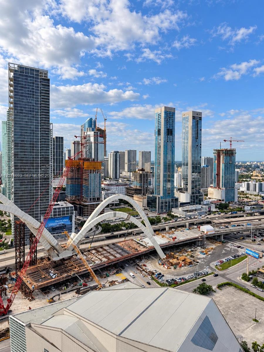 Elevated perspective of the metropolitan skyline featuring high-rise towers, multi-lane infrastructure, and expansive urban scenery