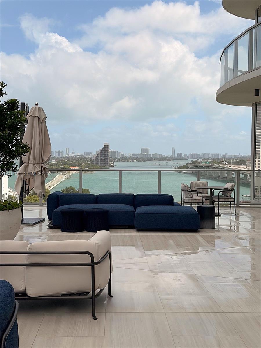 Expansive outdoor terrace featuring large-format tile flooring and a glass panel railing