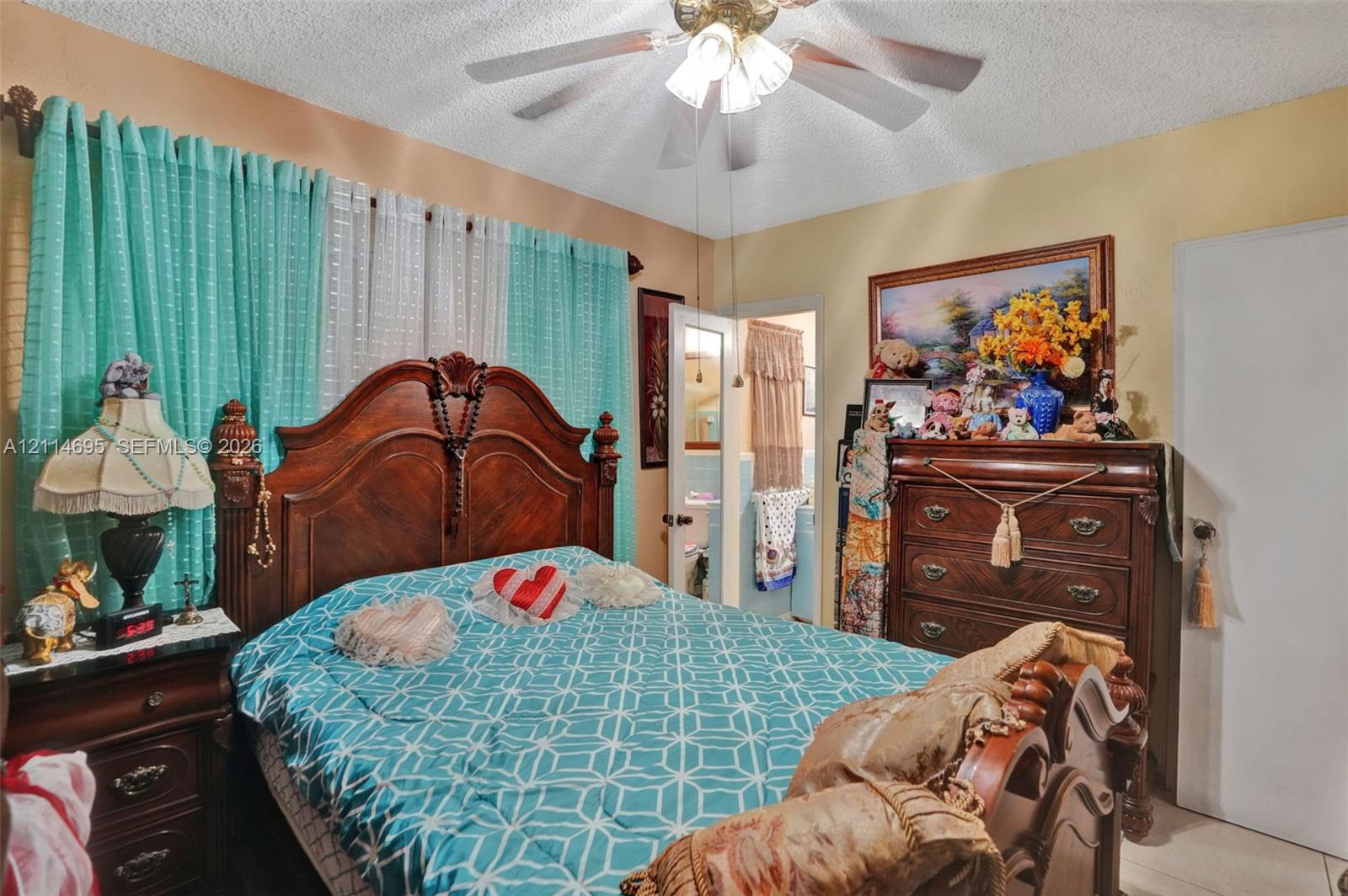 Room featuring a ceiling fan with integrated light fixture and a textured ceiling finish