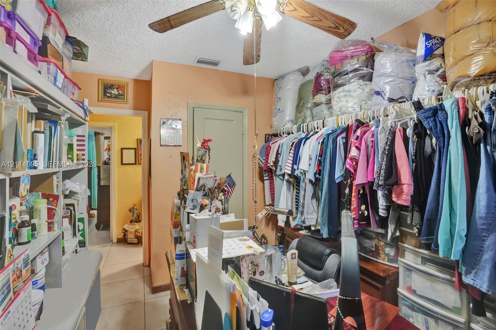 Built-in storage shelving, ceiling fan with integrated lighting, and tile flooring
