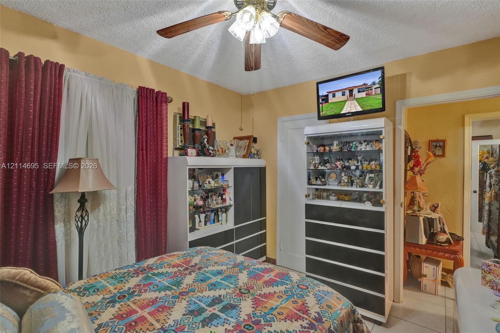 Ceiling-mounted multi-blade fan with integrated light fixture and neutral wall finish