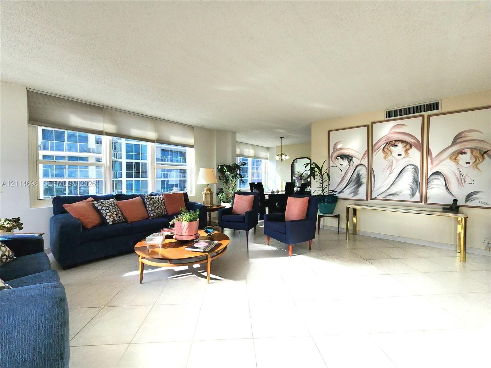 Open-concept living area featuring large-format tile flooring, Large Hurricane Picture Windows
