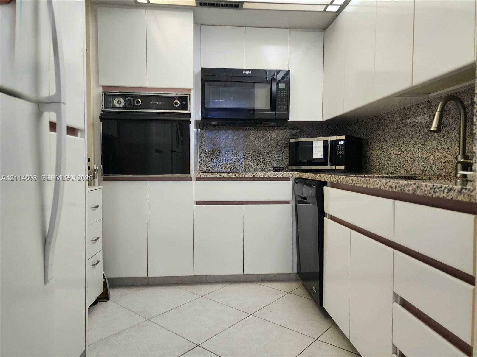 Kitchen featuring flat-panel white cabinetry