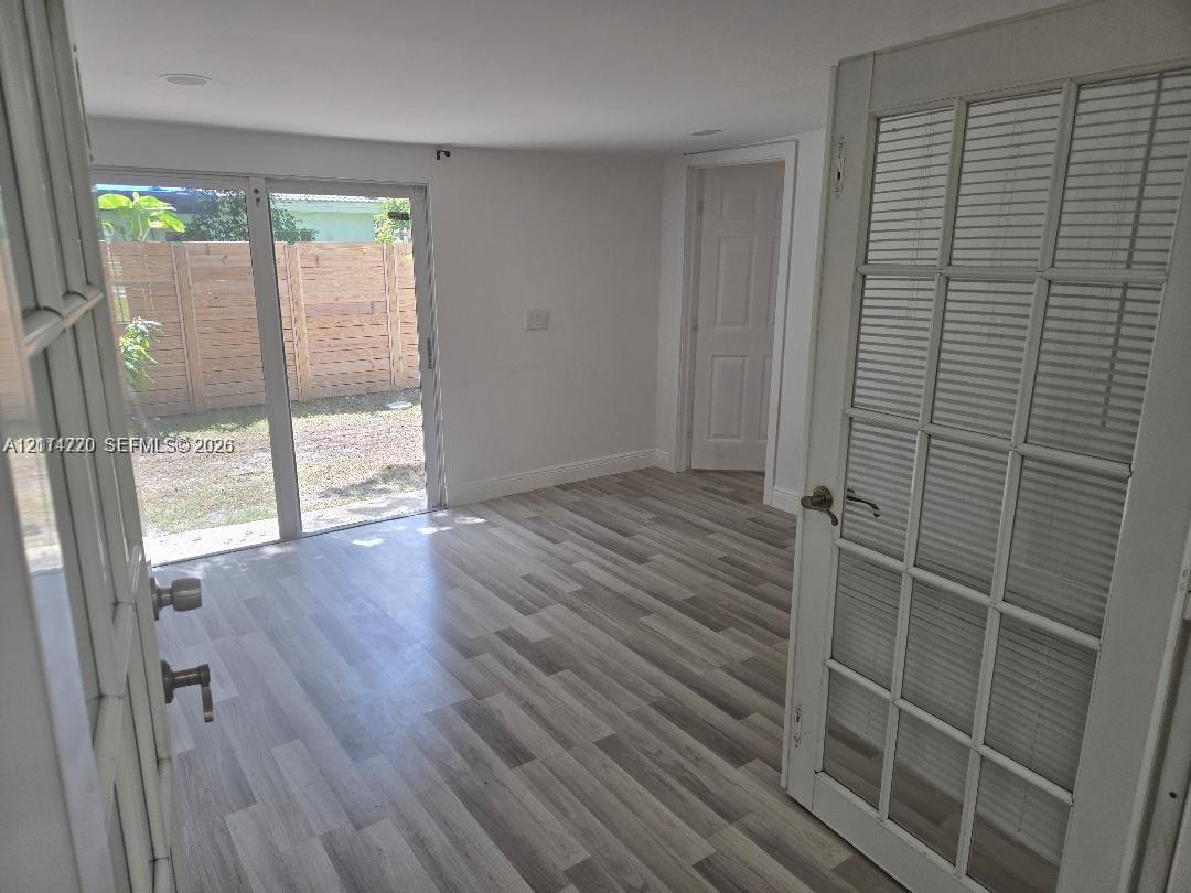 Interior space featuring wood-finish flooring, recessed lighting, and a multi-lite door with integrated blinds Interior space featuring wood-finish flooring, recessed lighting, and a multi-lite door with integrated blinds
