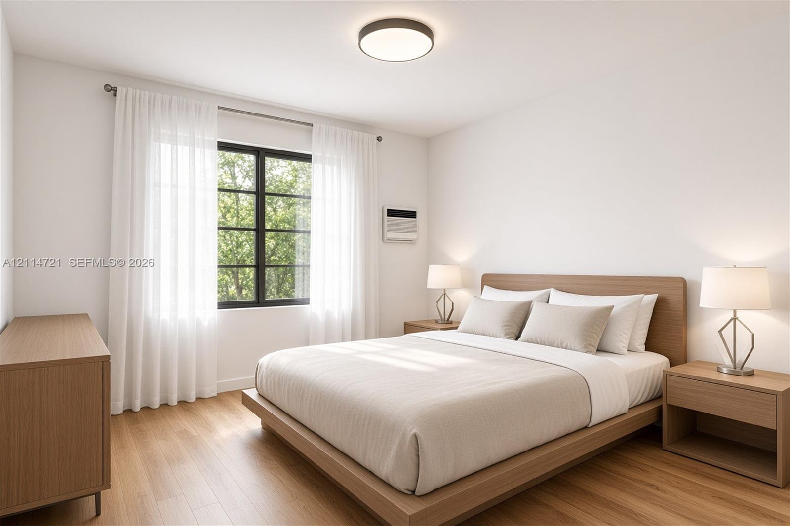 Bedroom featuring wood-finish flooring, a multi-pane window with a black frame, and a flush-mount ceiling light fixture