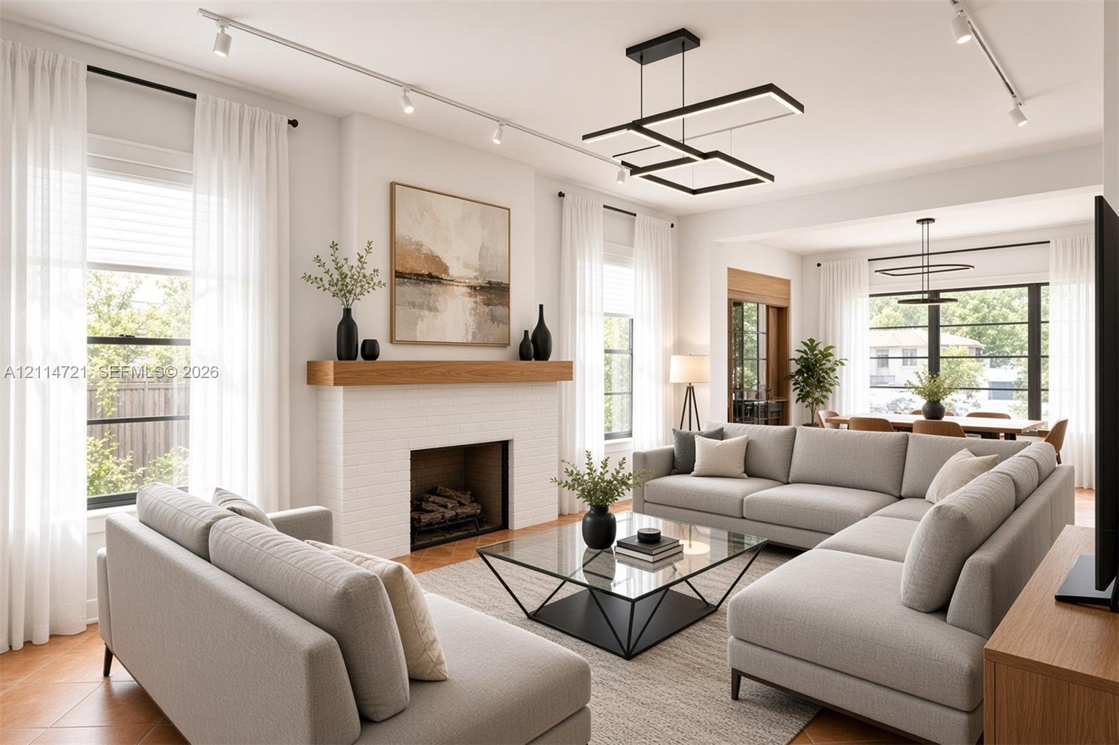 Living area featuring a painted brick fireplace with a wood mantel, multi-level geometric pendant lighting, wood-finish flooring, and track lighting