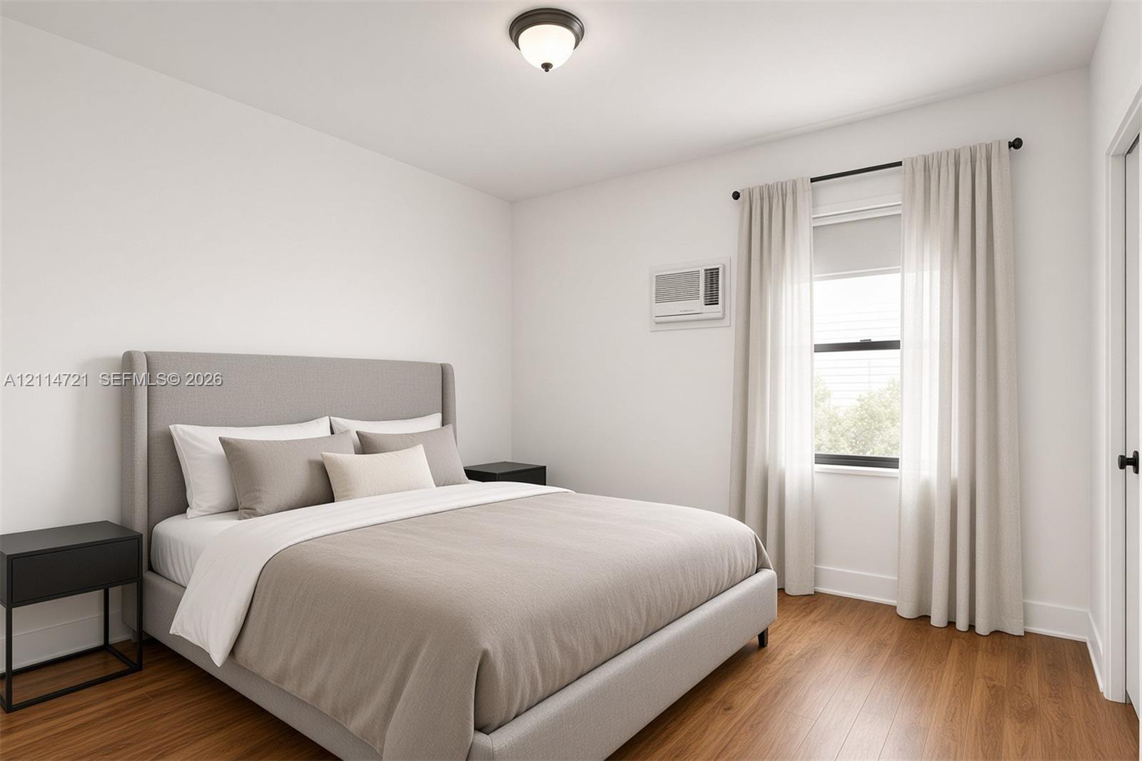 Neutral-toned bedroom featuring wood-finish flooring, a single-hung window, and a wall-mounted air conditioning unit
