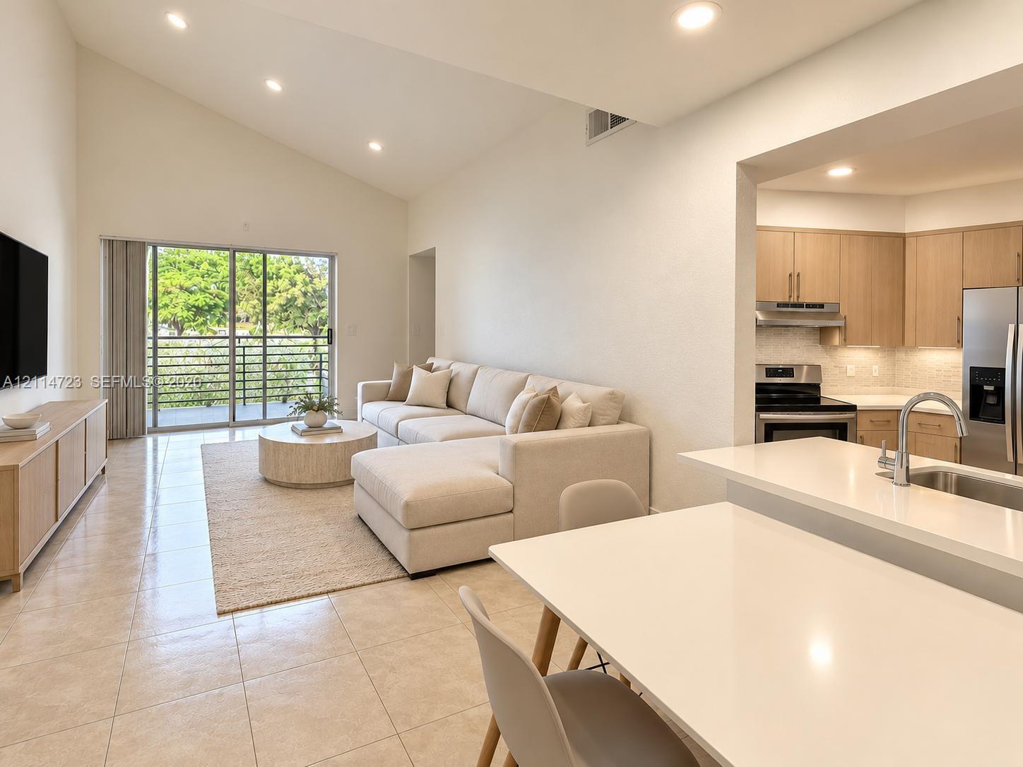 Vaulted ceilings, neutral tile flooring, sliding glass balcony door, quartz countertops, and stainless steel kitchen appliances Vaulted ceilings, neutral tile flooring, sliding glass balcony door, quartz countertops, and stainless steel kitchen appliances
