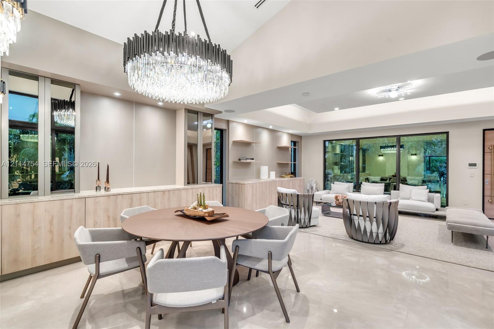 Covered outdoor kitchen featuring stainless steel cabinetry, a professional-grade grill, and a matching range hood, complete with natural stone flooring and a pool