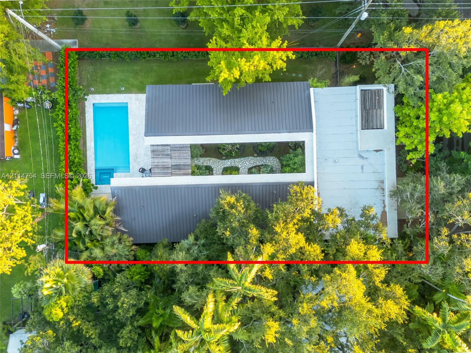 Aerial perspective featuring a heavily wooded residential lot with established mature trees and dense perimeter vegetation