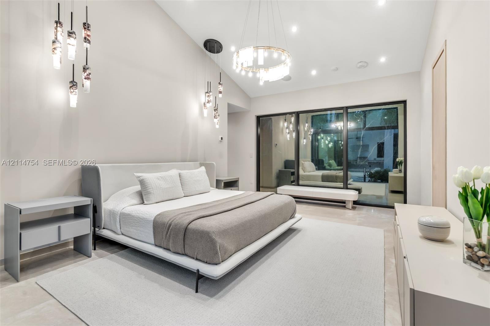 Stone-tiled walls and flooring paired with a freestanding soaking tub, brass fixtures, glass-enclosed walk-in shower, and dual vanities with integrated shelving