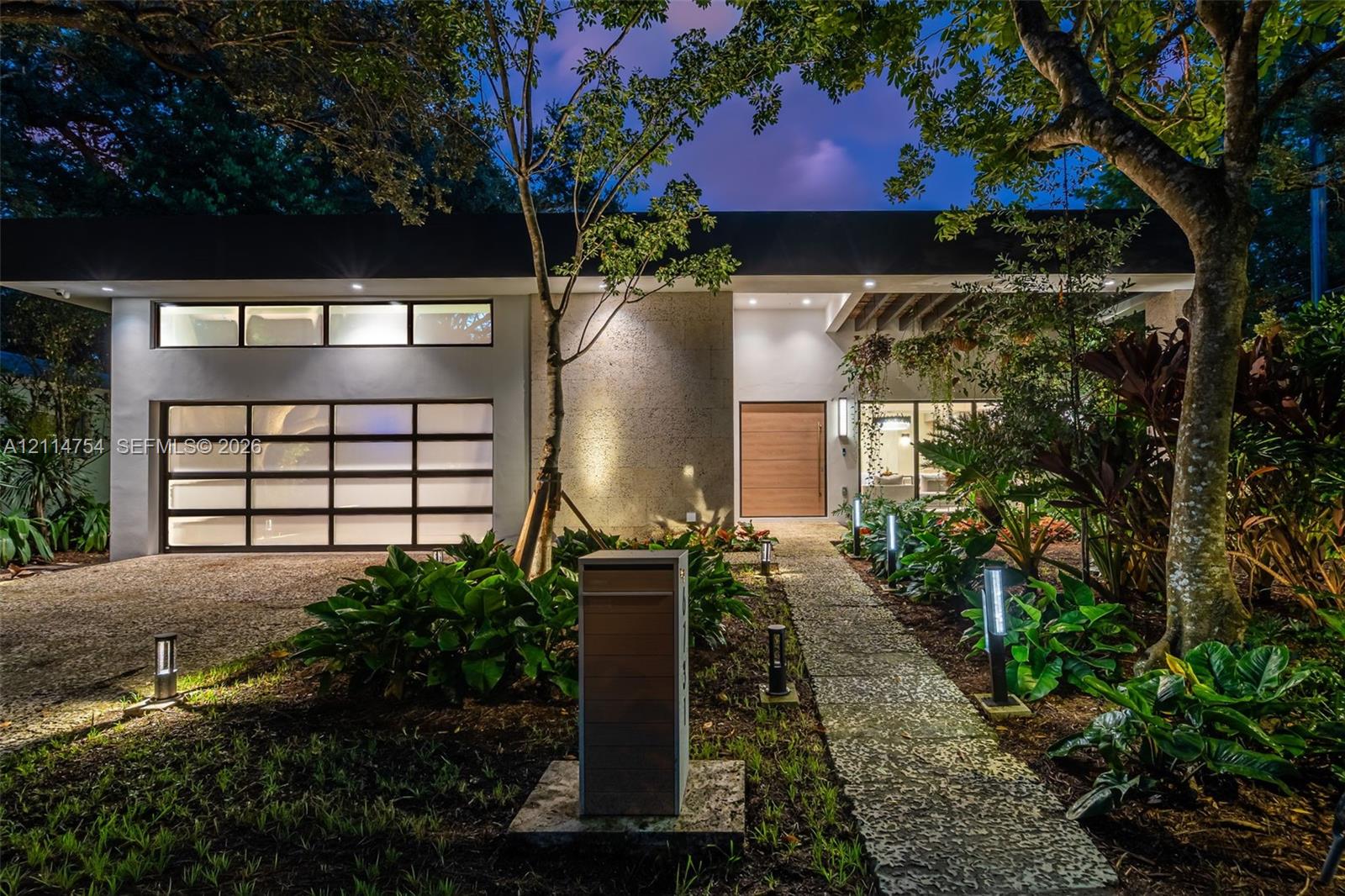 Aerial perspective featuring a rectangular swimming pool with hardscaped surround, integrated central garden courtyard, and standing seam metal roofing