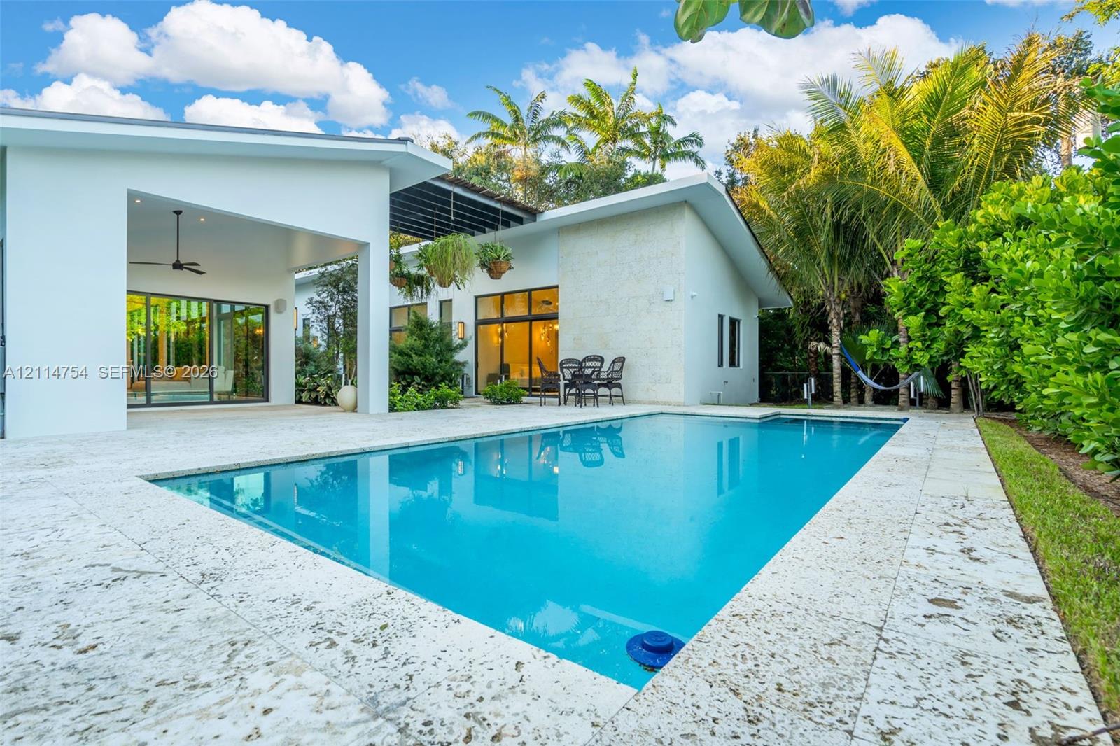Enclosed garden courtyard featuring patterned stone pavers, desert-inspired landscaping, integrated pathway lighting, and multiple floor-to-ceiling windows