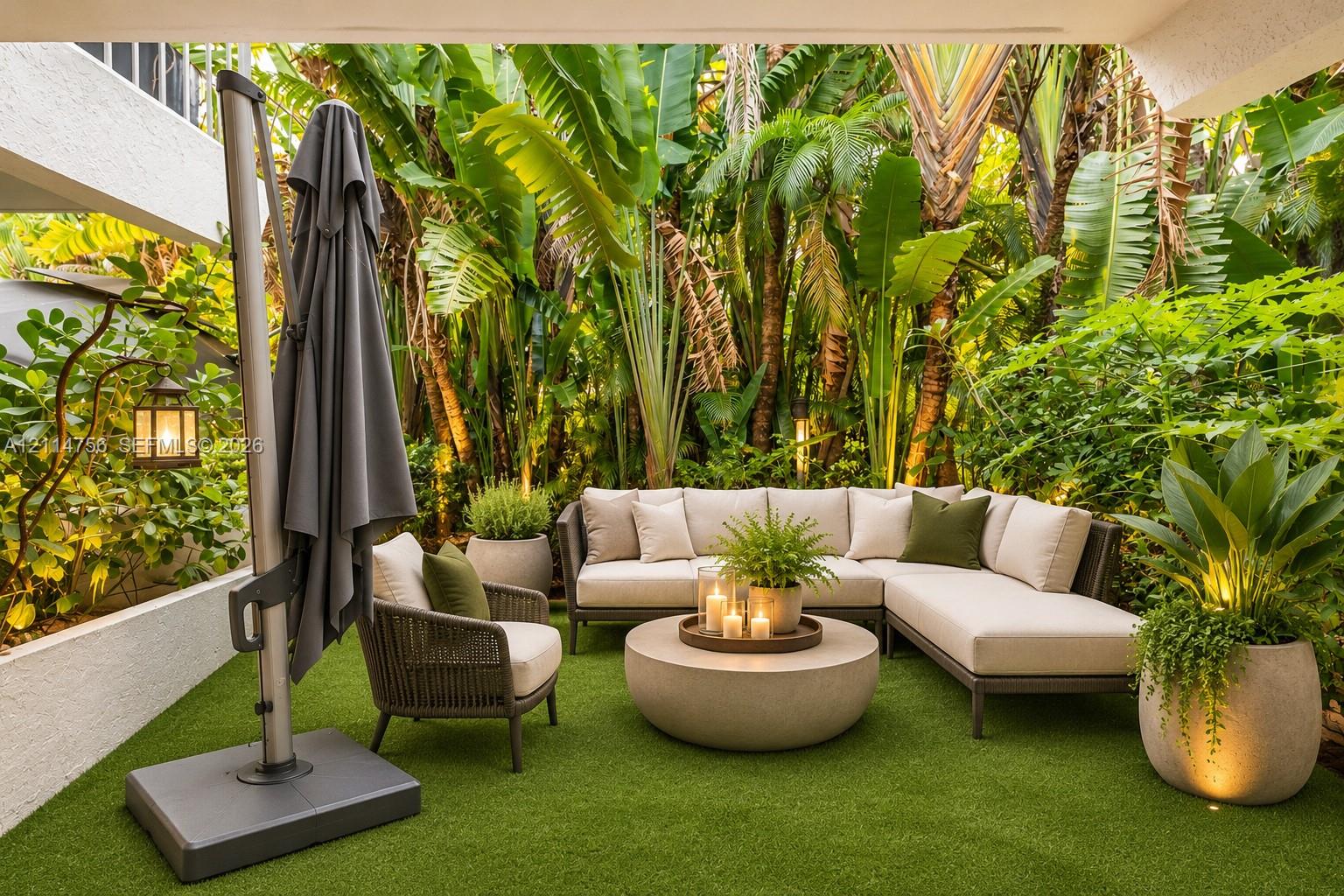 Covered patio featuring synthetic turf, structured retaining walls, and mature tropical landscaping