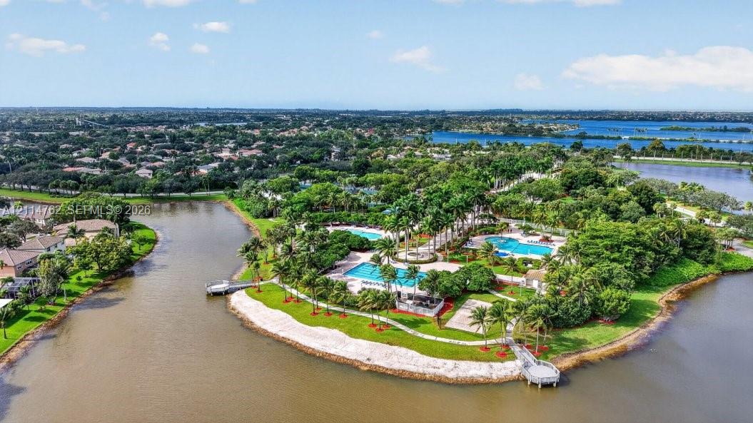 Waterfront community amenities featuring multiple swimming pools, paved walking paths, mature landscaping, and private boat docks
