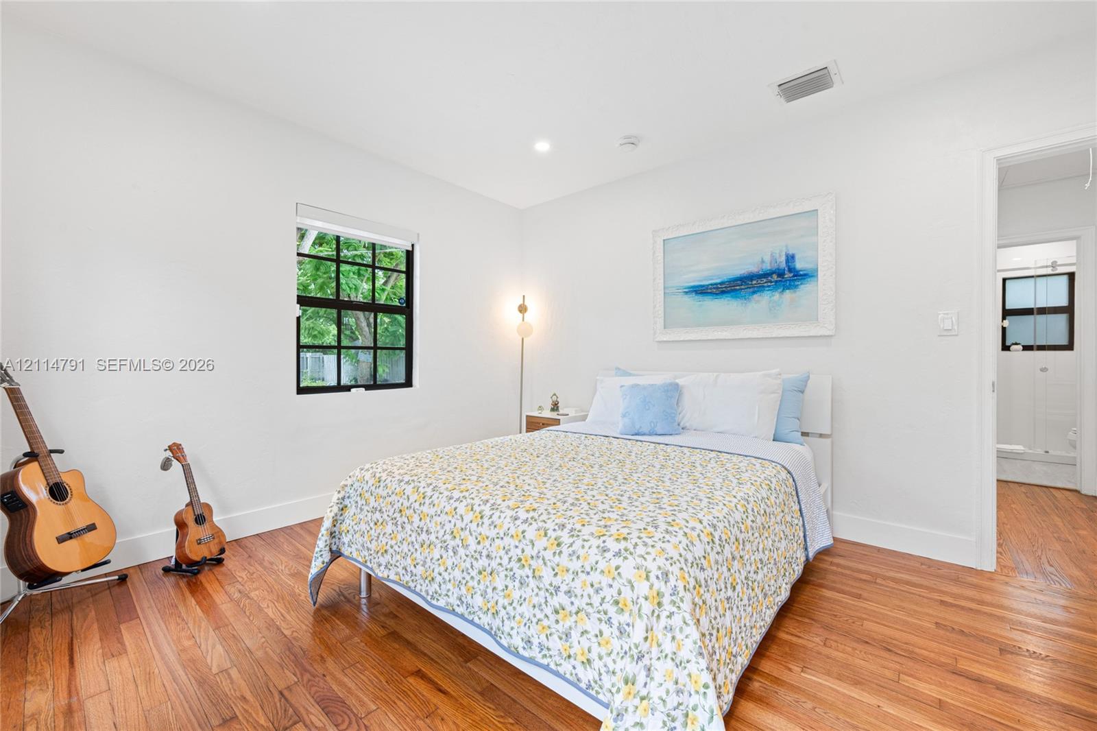 Wood-finish flooring, recessed lighting, and a window with black-framed muntins