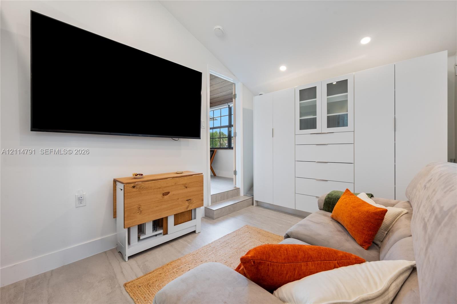 Vaulted ceiling featuring recessed lighting, extensive built-in floor-to-ceiling cabinetry, and light-tone tile flooring
