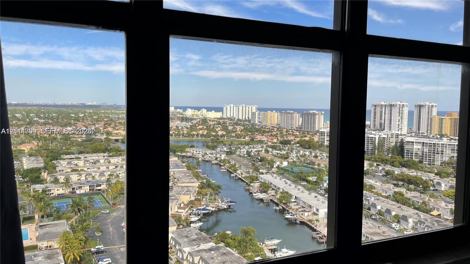 Floor-to-ceiling windows featuring panoramic urban, waterway, and coastal scenery