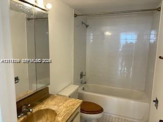 Bathroom featuring a bathtub with full-height subway tile surround, a mirrored medicine cabinet, and a stone-finish vanity countertop