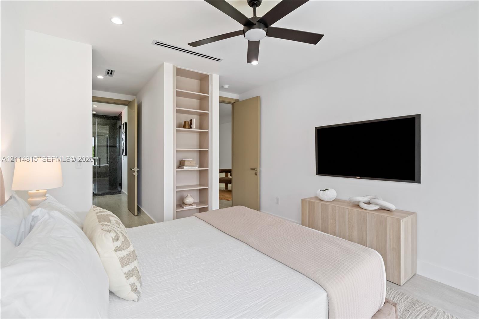 Built-in open shelving, contemporary ceiling fan, recessed lighting, and neutral wall tones
