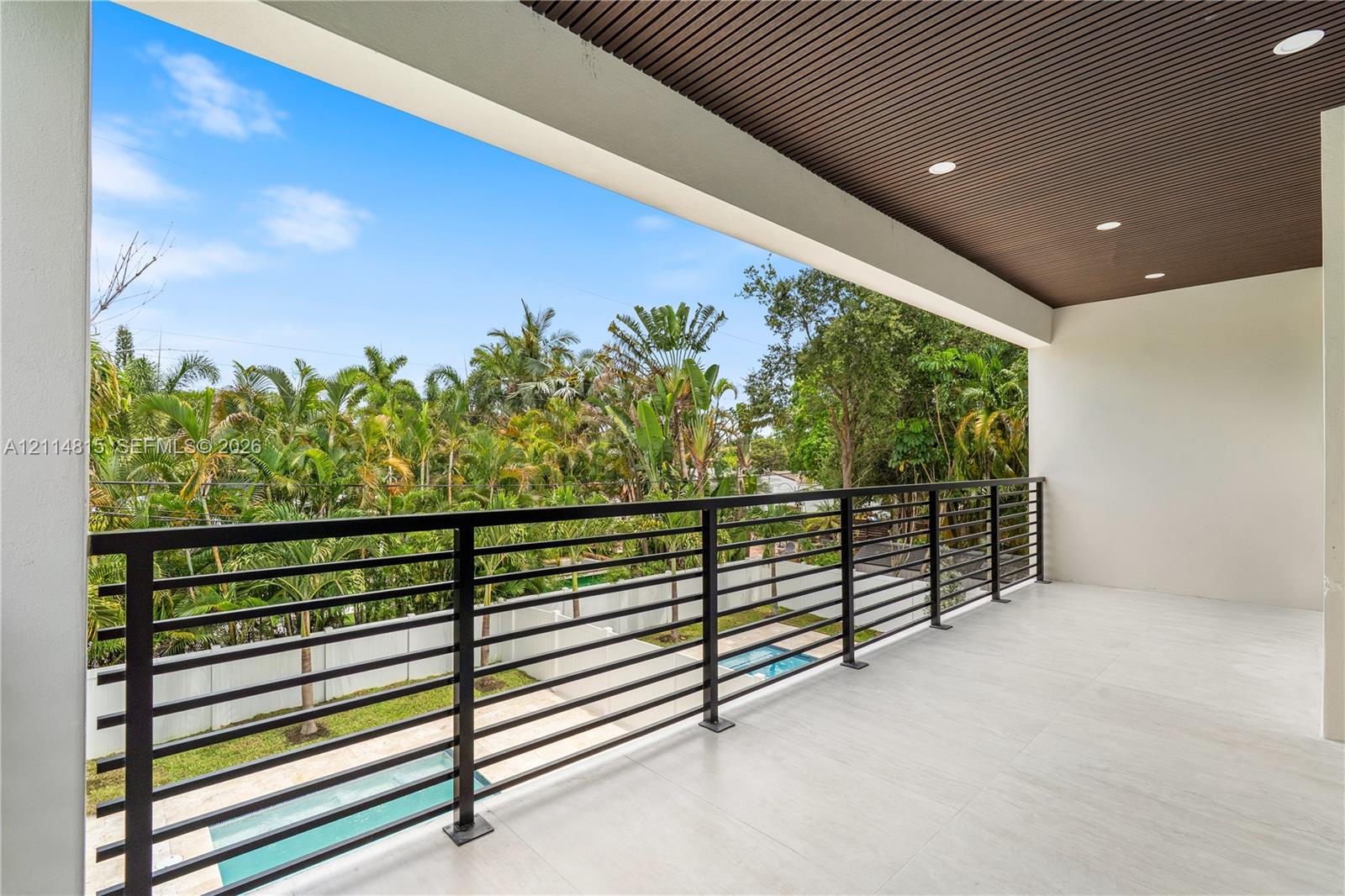 Covered terrace featuring large-format tile flooring, a slatted wood-finish ceiling, recessed lighting, and a horizontal bar metal railing
