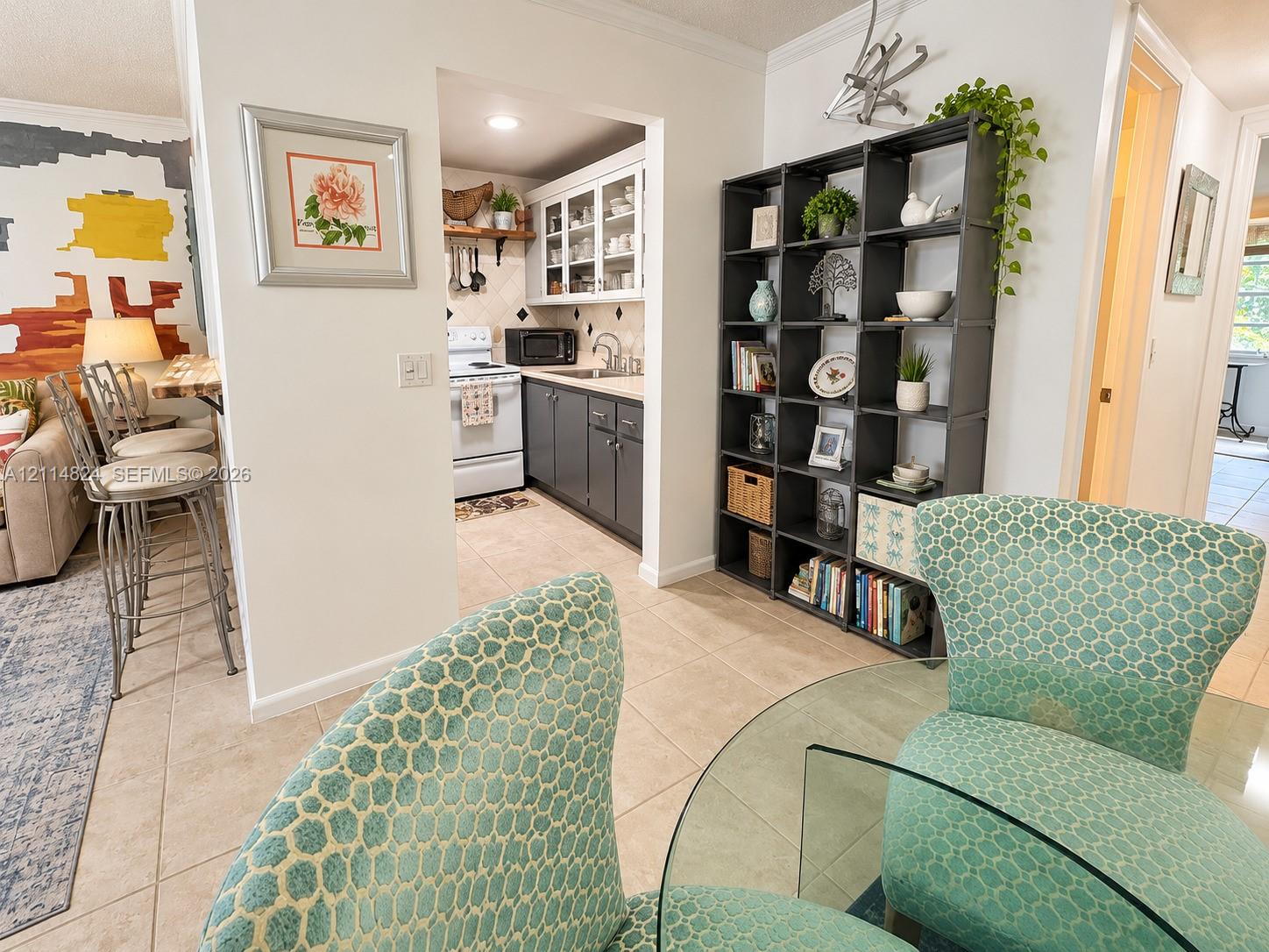 Kitchen featuring grey lower cabinetry, white upper cabinetry with glass-front accents, and tile flooring
