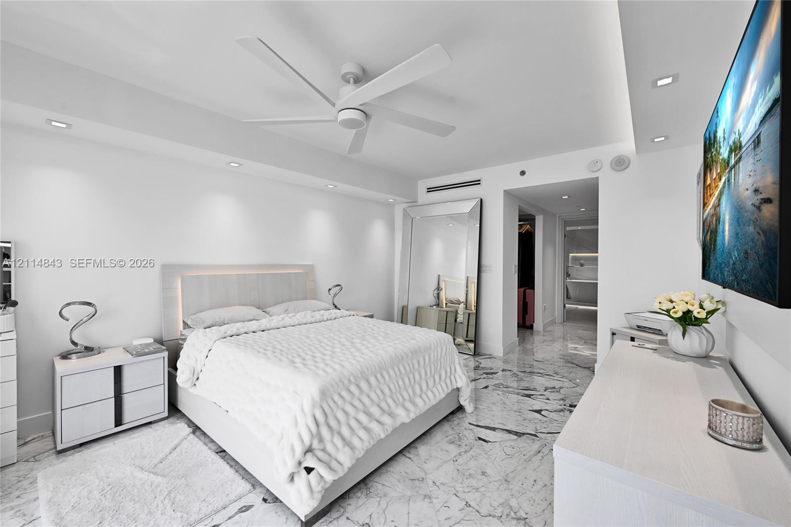Spacious room featuring polished stone flooring, recessed ceiling lighting, a contemporary multi-blade ceiling fan, and smooth finish walls