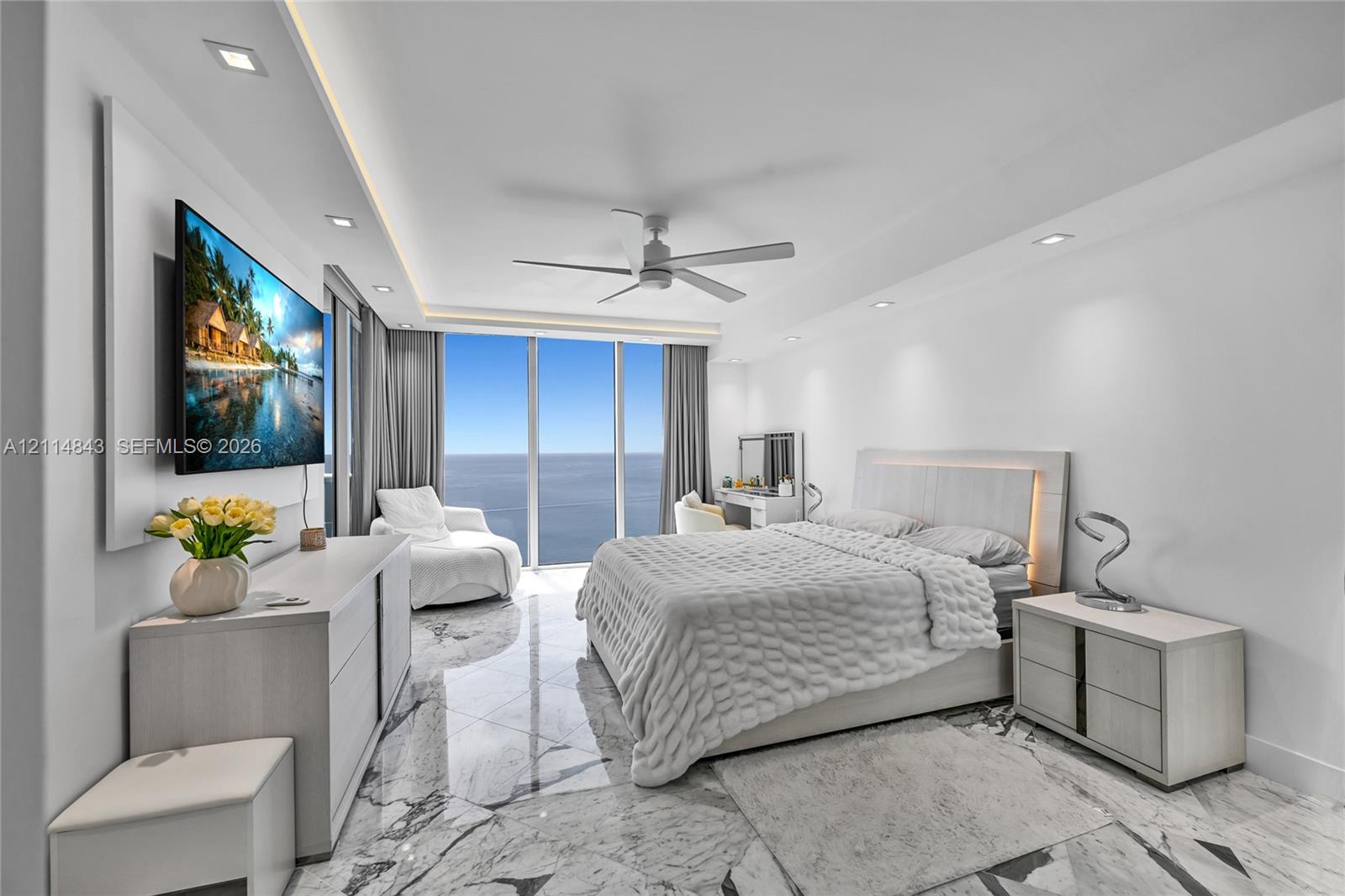 Polished stone flooring, floor-to-ceiling glass windows, recessed ceiling lighting, and a ceiling fan
