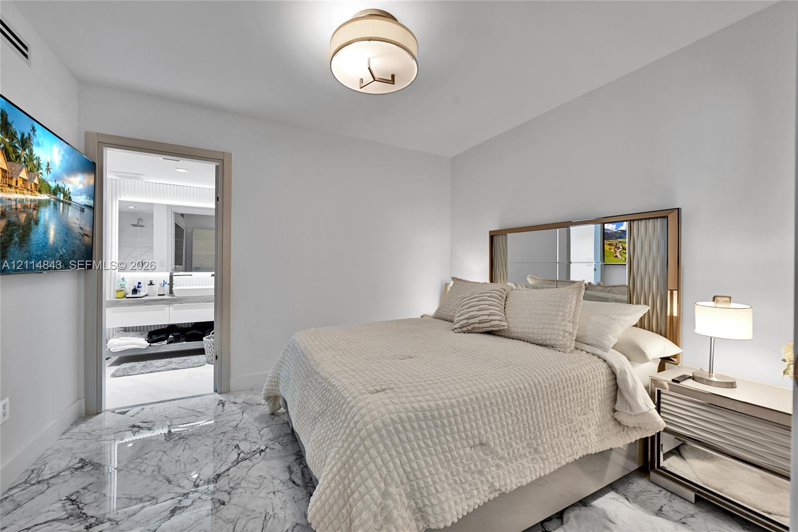 Polished stone flooring, recessed lighting, flush-mount drum fixture, and built-in mirror panel