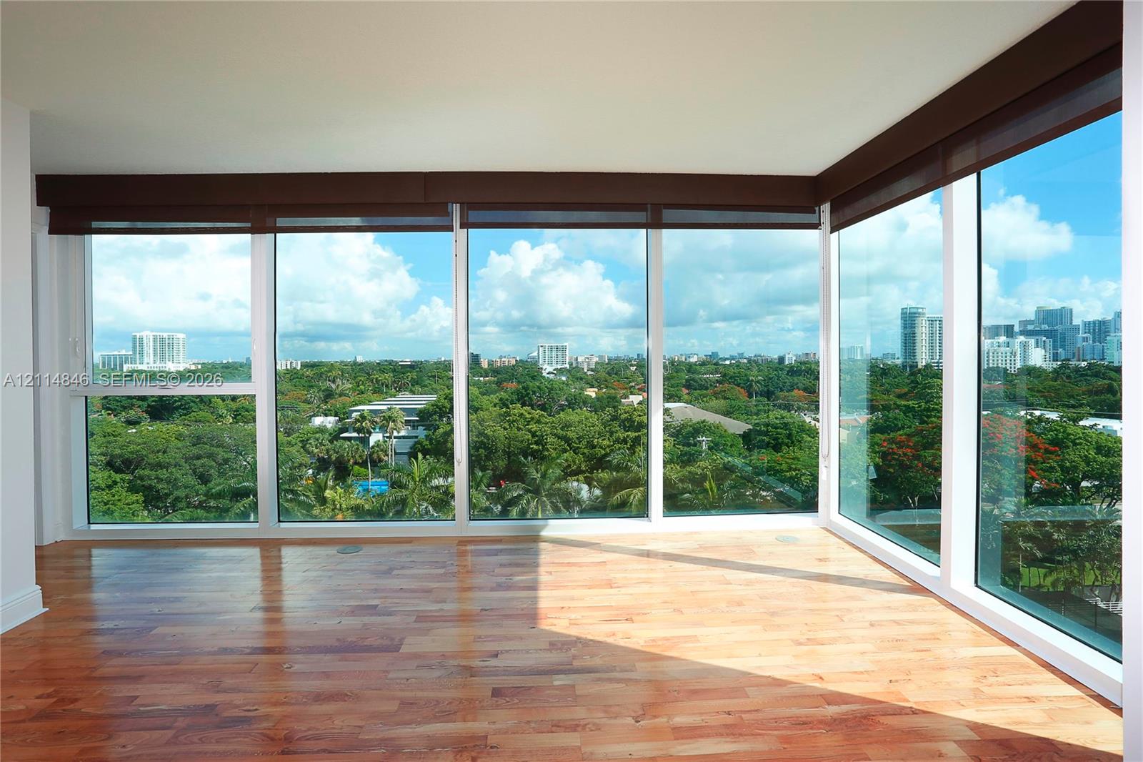 Floor-to-ceiling windows, wood-finish flooring, and recessed automated window shades