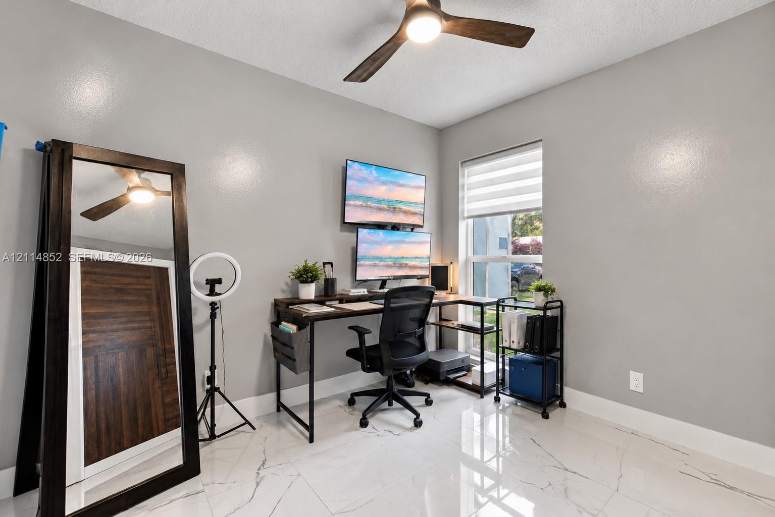 Polished tile flooring with veining, neutral interior paint, and a modern ceiling fan with integrated lighting