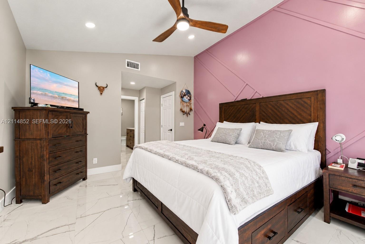Geometric wall molding, polished tile flooring, and a modern ceiling fan with integrated lighting