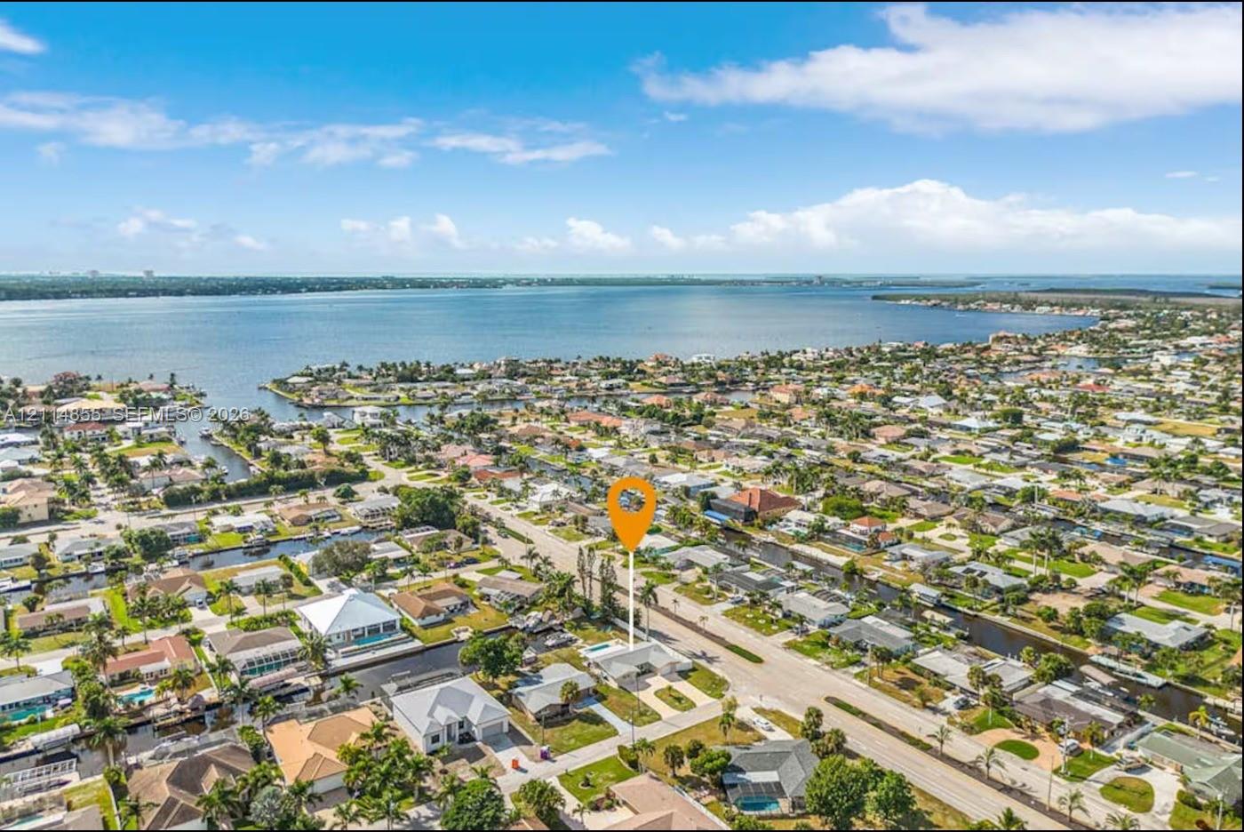 Aerial perspective of a coastal residential property featuring a backyard swimming pool and direct proximity to canal waterways