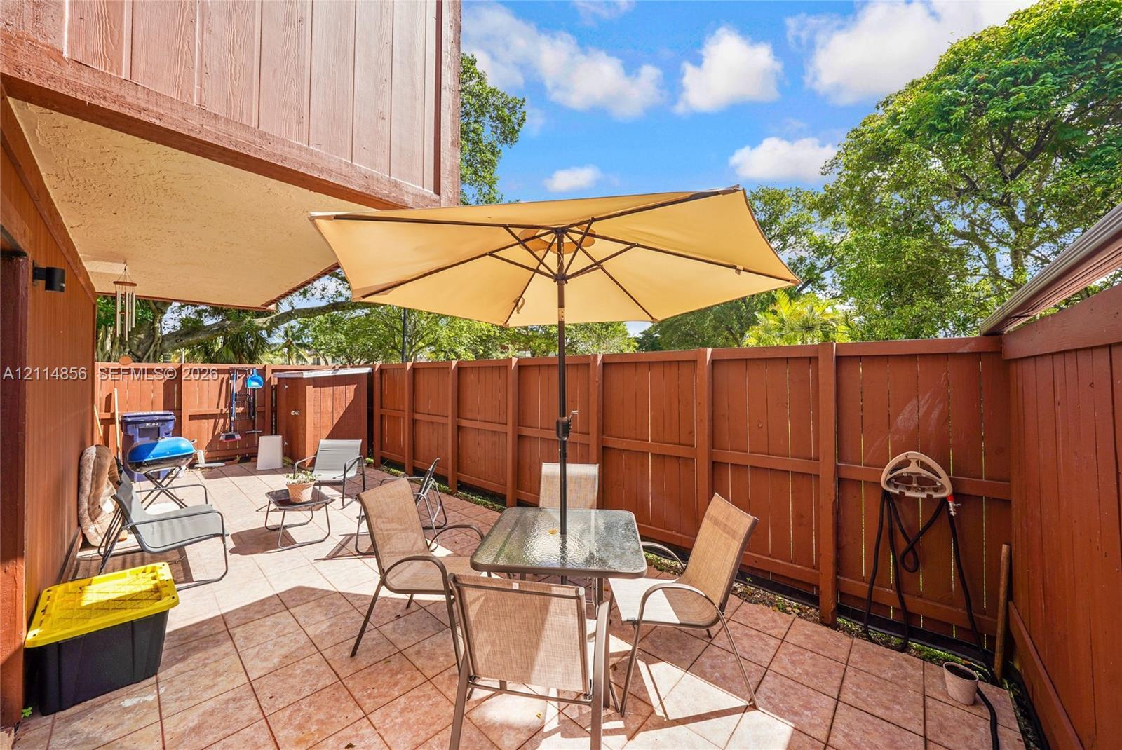 Private patio featuring tile flooring and wood-style privacy fencing