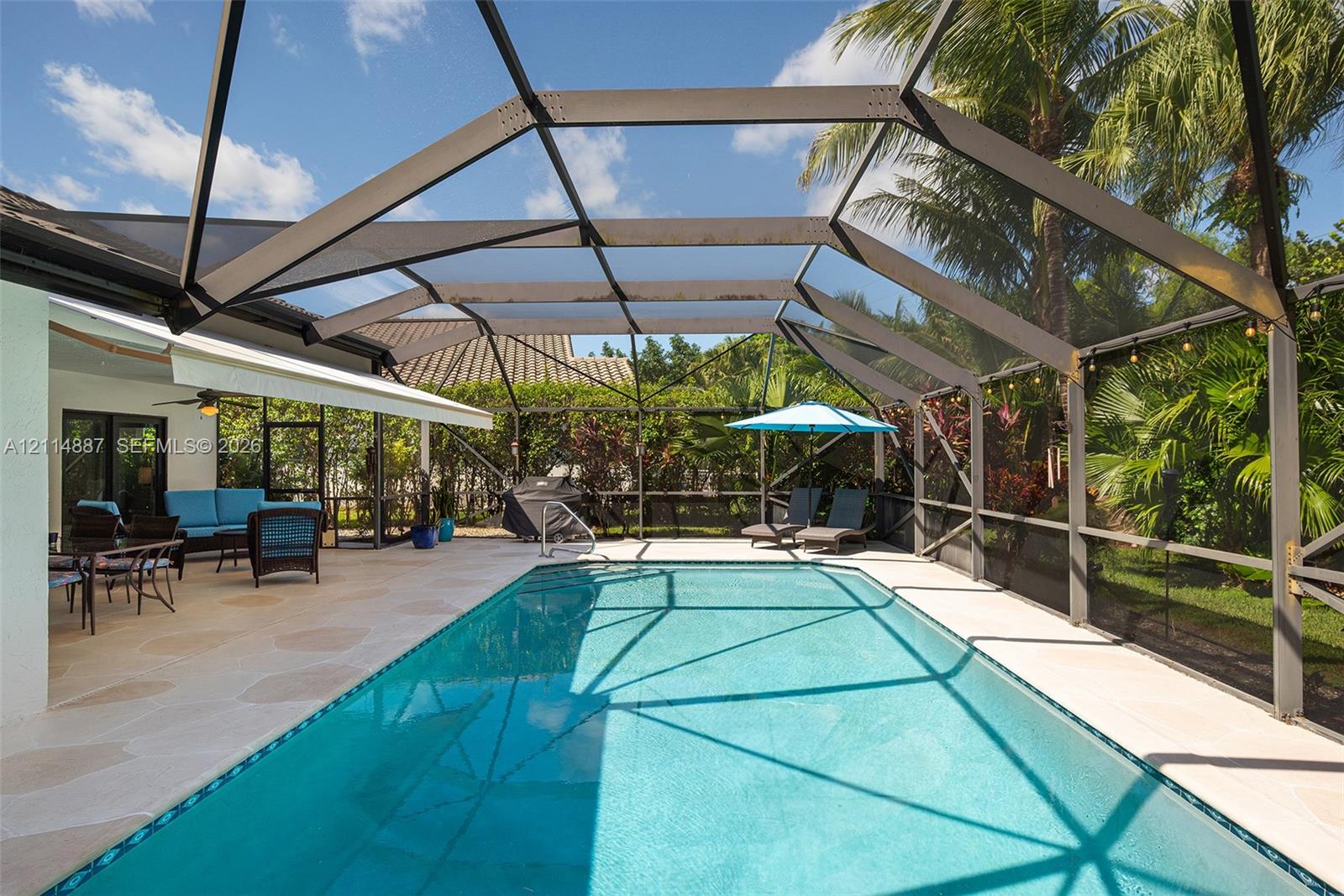 Screened-in patio enclosure featuring a swimming pool, concrete deck, and perimeter landscaping