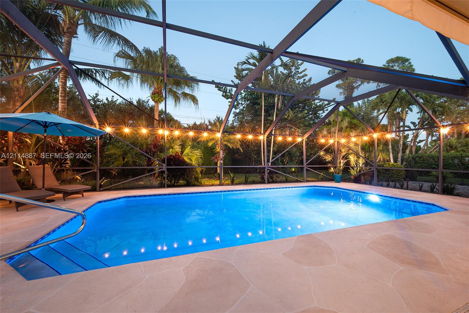 Screened-in outdoor swimming pool with stone-finish decking and built-in steps
