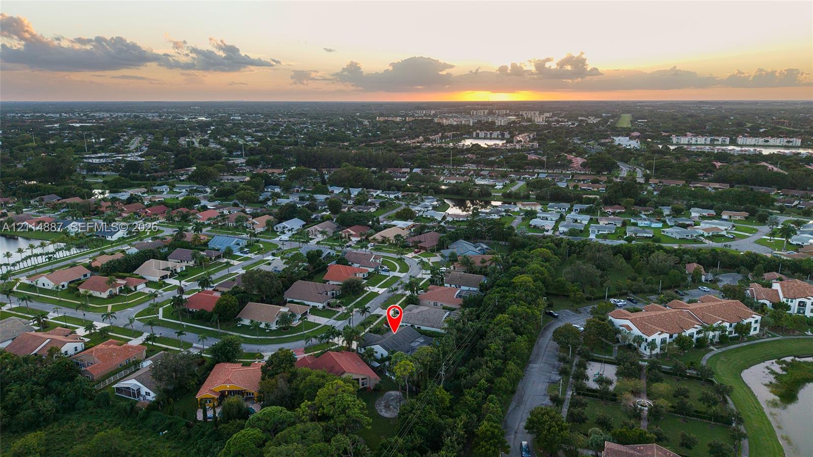 Aerial perspective of a residential property featuring a tiled roof and mature perimeter landscaping