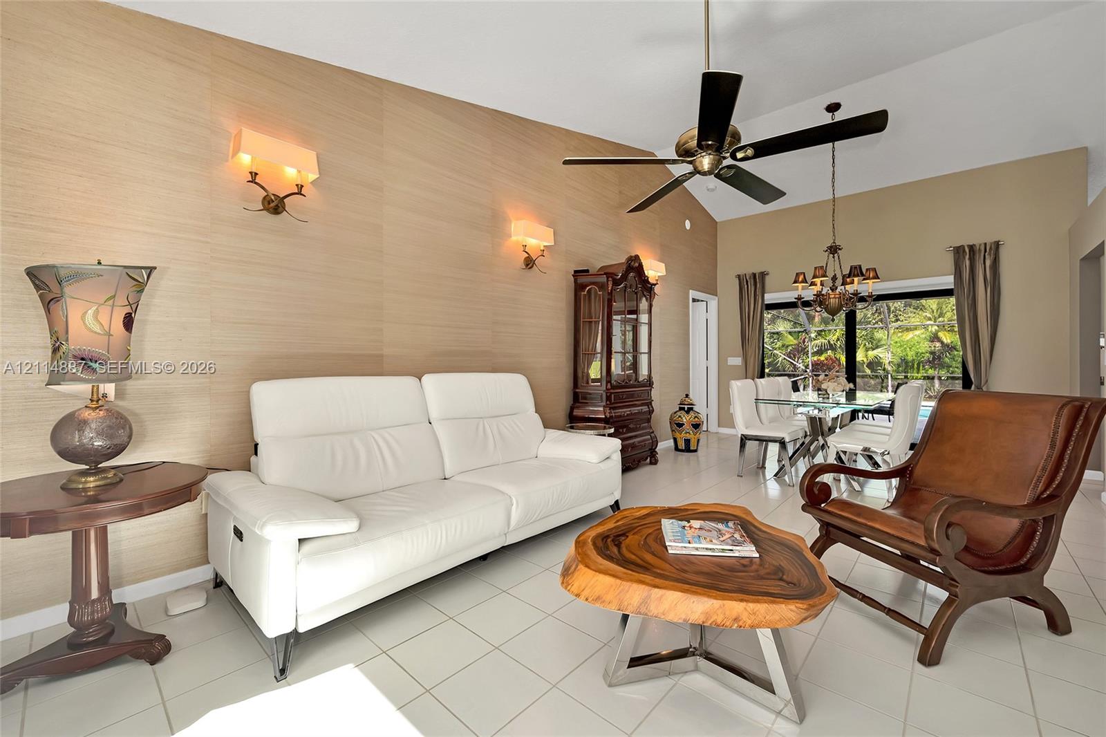 Vaulted ceiling featuring a central multi-blade ceiling fan, textured wall covering, and recessed lighting