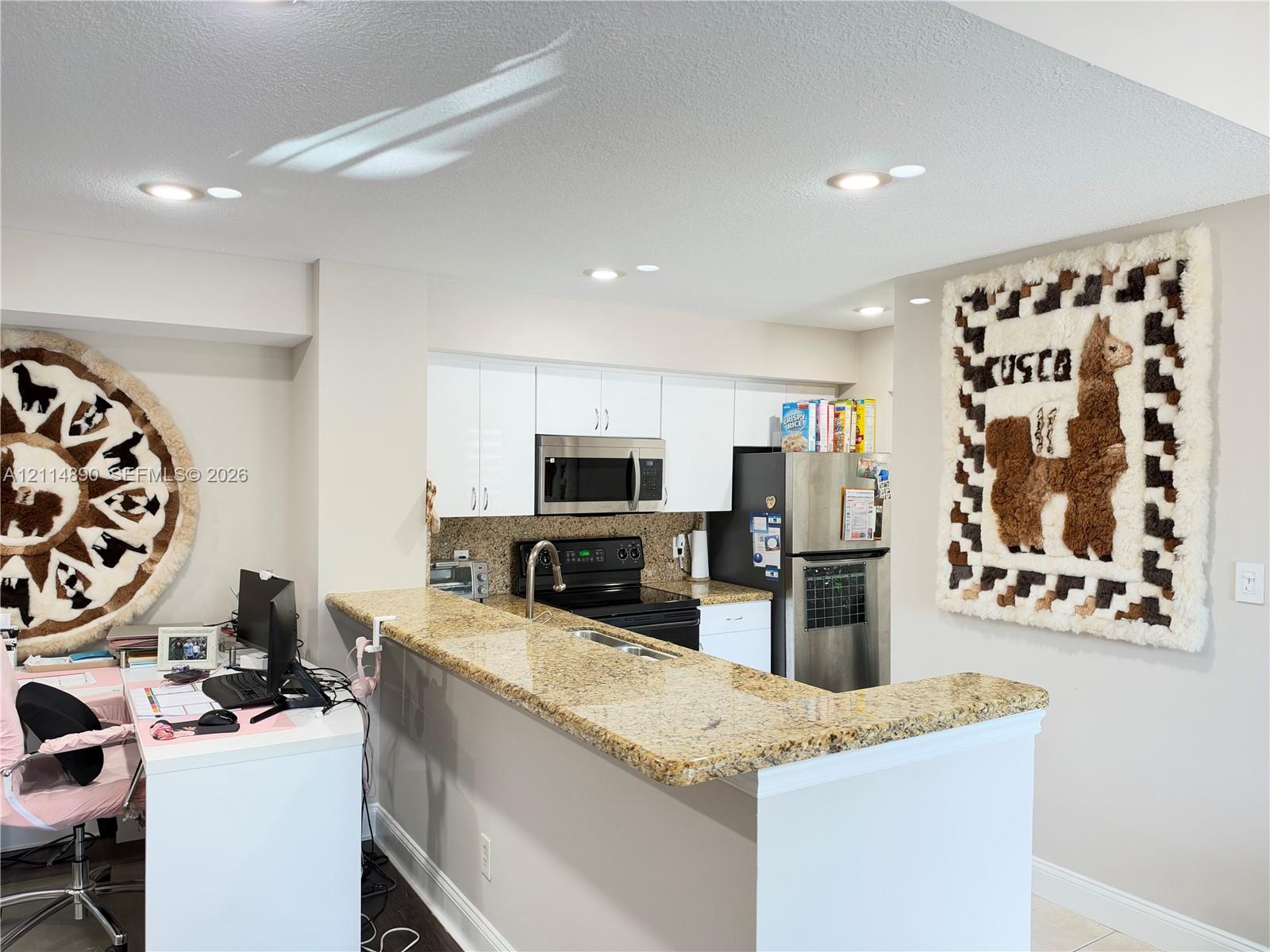 Kitchen featuring white cabinetry, stone-finish countertops, stainless steel appliances, and recessed lighting