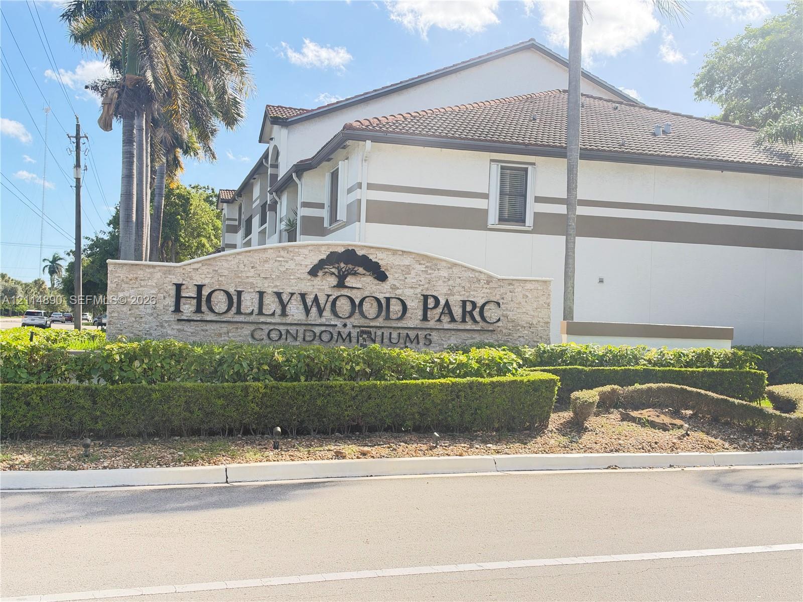 Stone-veneer community monument sign featuring manicured landscaping and mature palm trees Stone-veneer community monument sign featuring manicured landscaping and mature palm trees