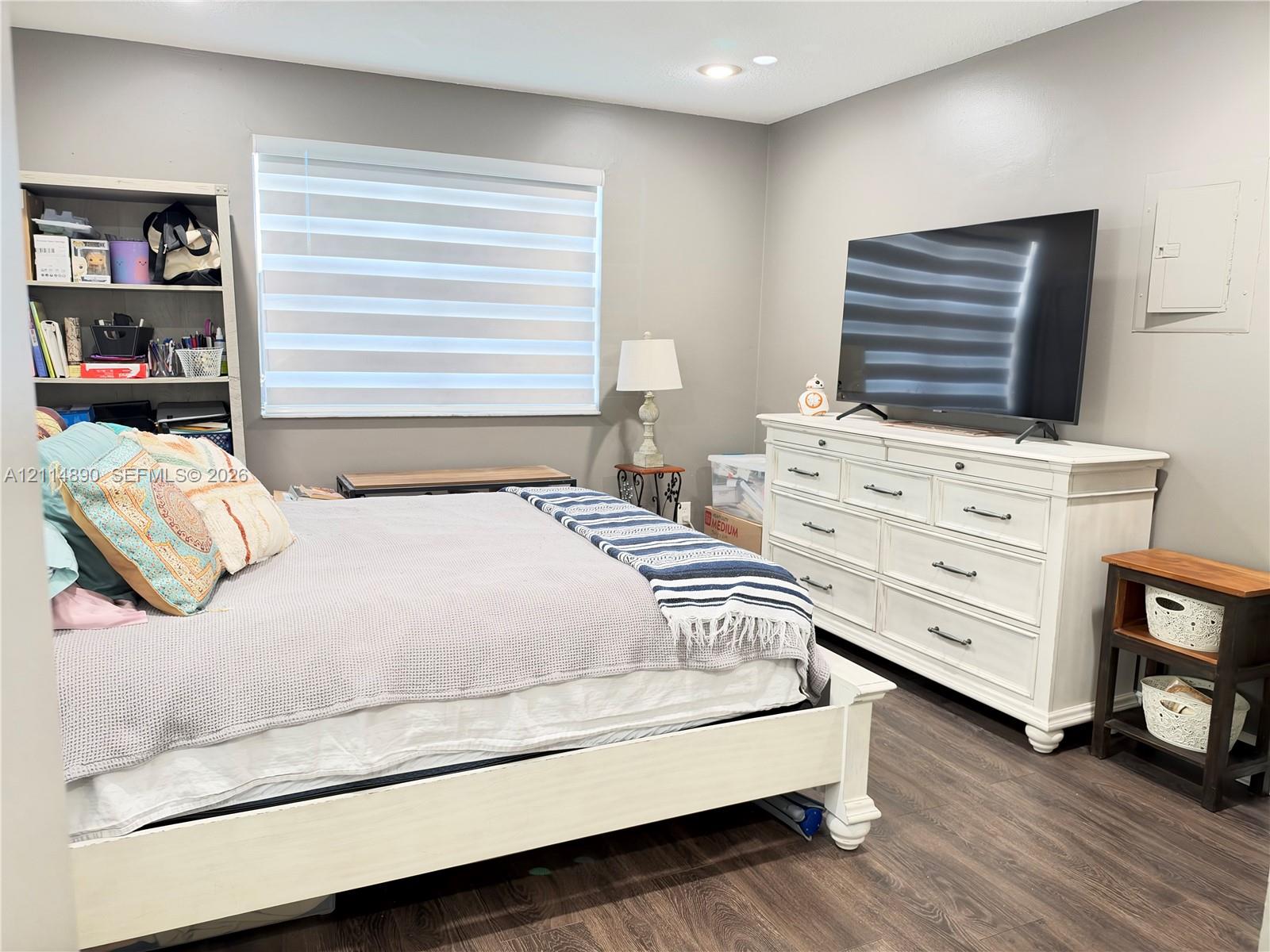 Neutral interior featuring wood-finish flooring, recessed ceiling lighting, and horizontal shade window treatments